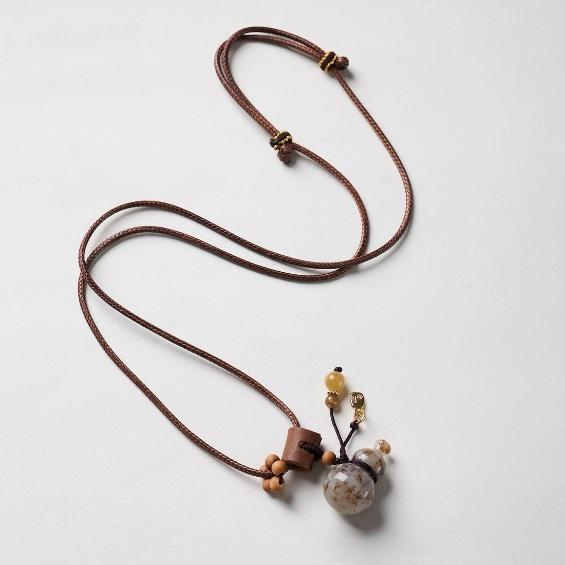 Hetian jade gourd (hulu) pendant on a waxed cord necklace, a traditional feng shui wu lou symbol of health and good fortune
