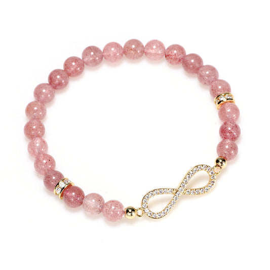 Natural strawberry quartz beaded bracelet with speckled pink stones resting on a soft neutral surface