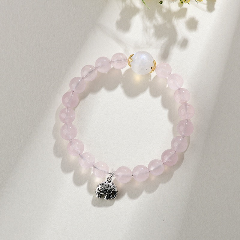 Rose quartz and moonstone beaded bracelet with a silver lucky elephant charm, showing moonstone's soft milky glow