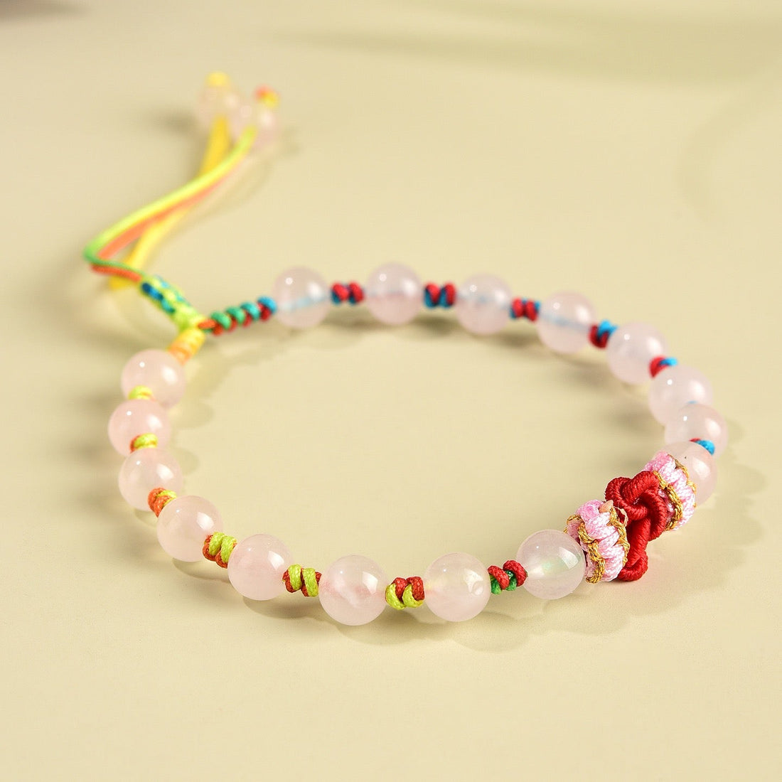Rose quartz bracelet with soft pink beads and a handwoven wisdom knot