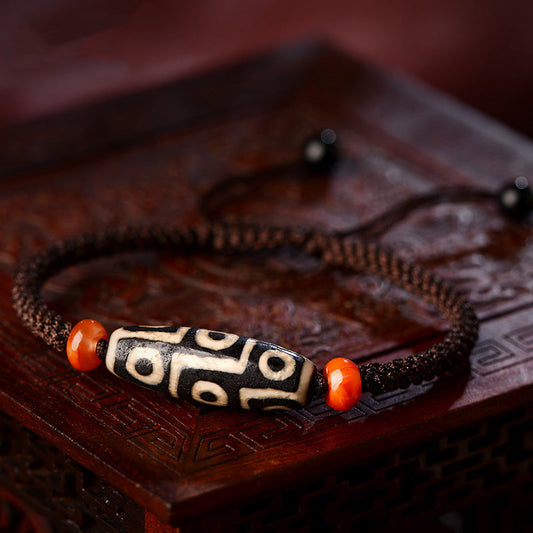 Tibetan nine-eye dzi bead prosperity string bracelet with patterned agate bead on a braided cord