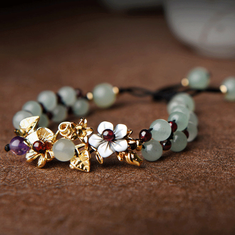 Green aventurine bead bracelet with gold flower petal charm, said to attract luck and opportunity